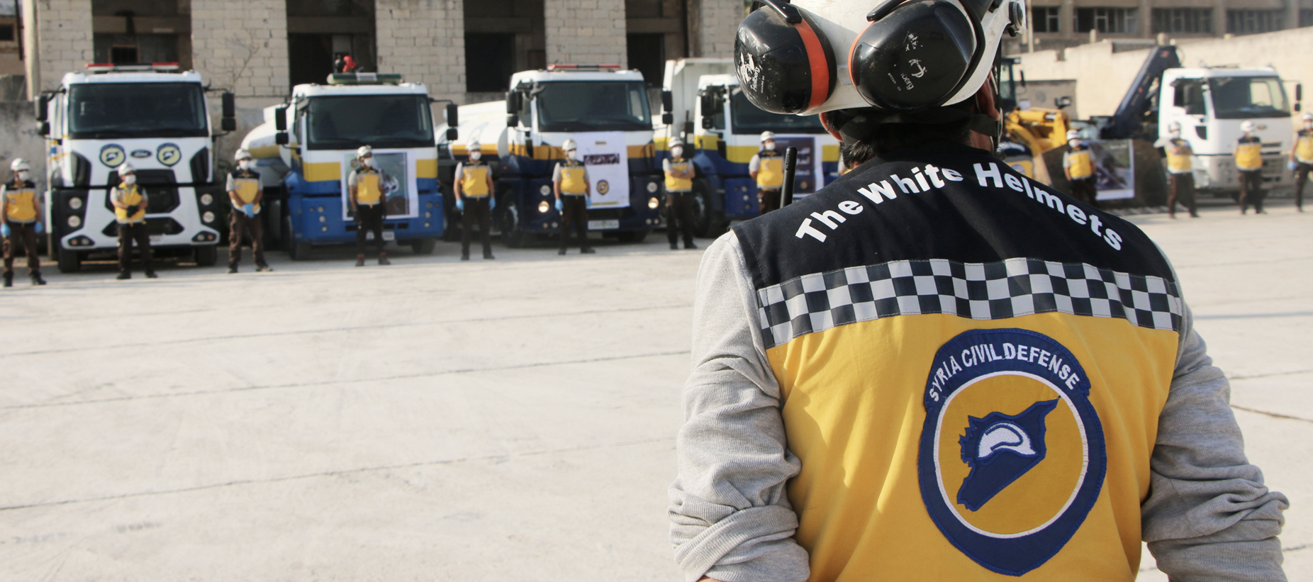 A white Helmets volunteer standing in front of a station.